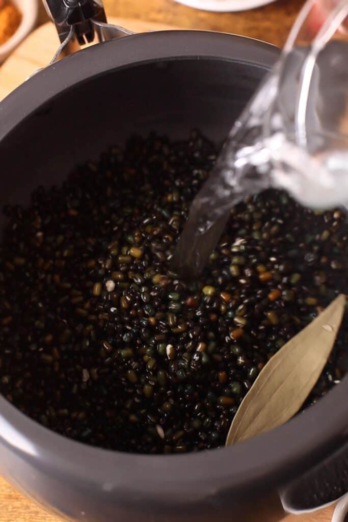 Soaked lentils, bay leaf and water added to pressure cooker.