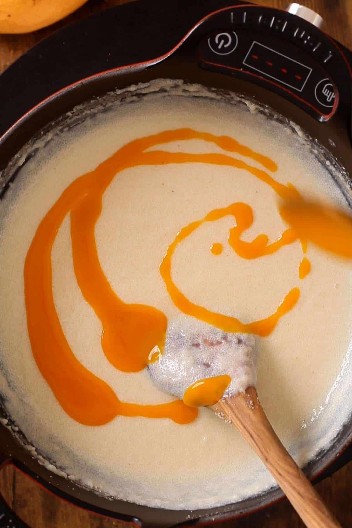 Fresh mango pulp is being added to phirni.