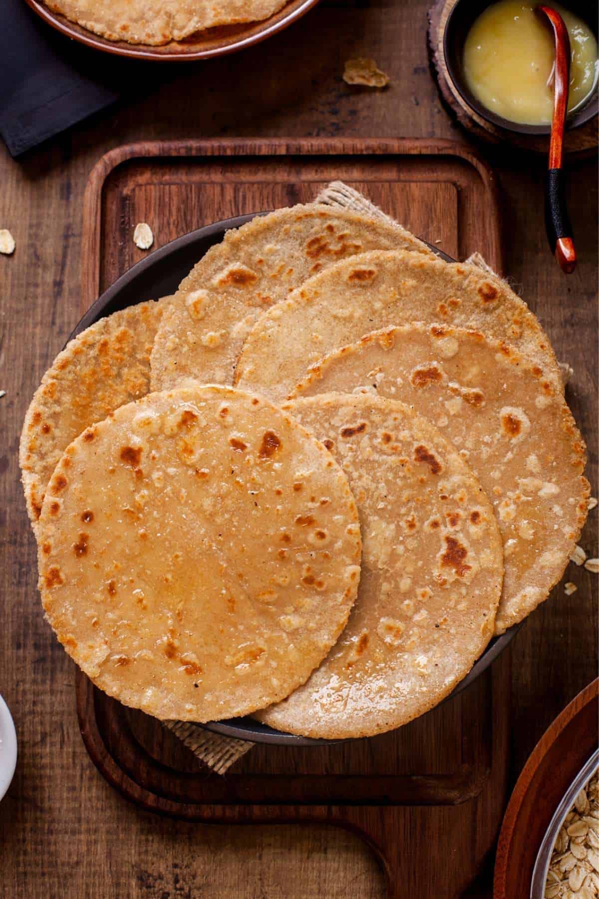 Oats Roti on a wooden board with ghee.