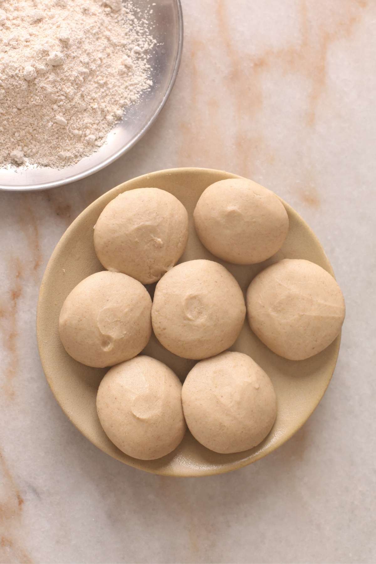 Divide the dough into equal portions. Smoothen each portion into a flattened ball. 
