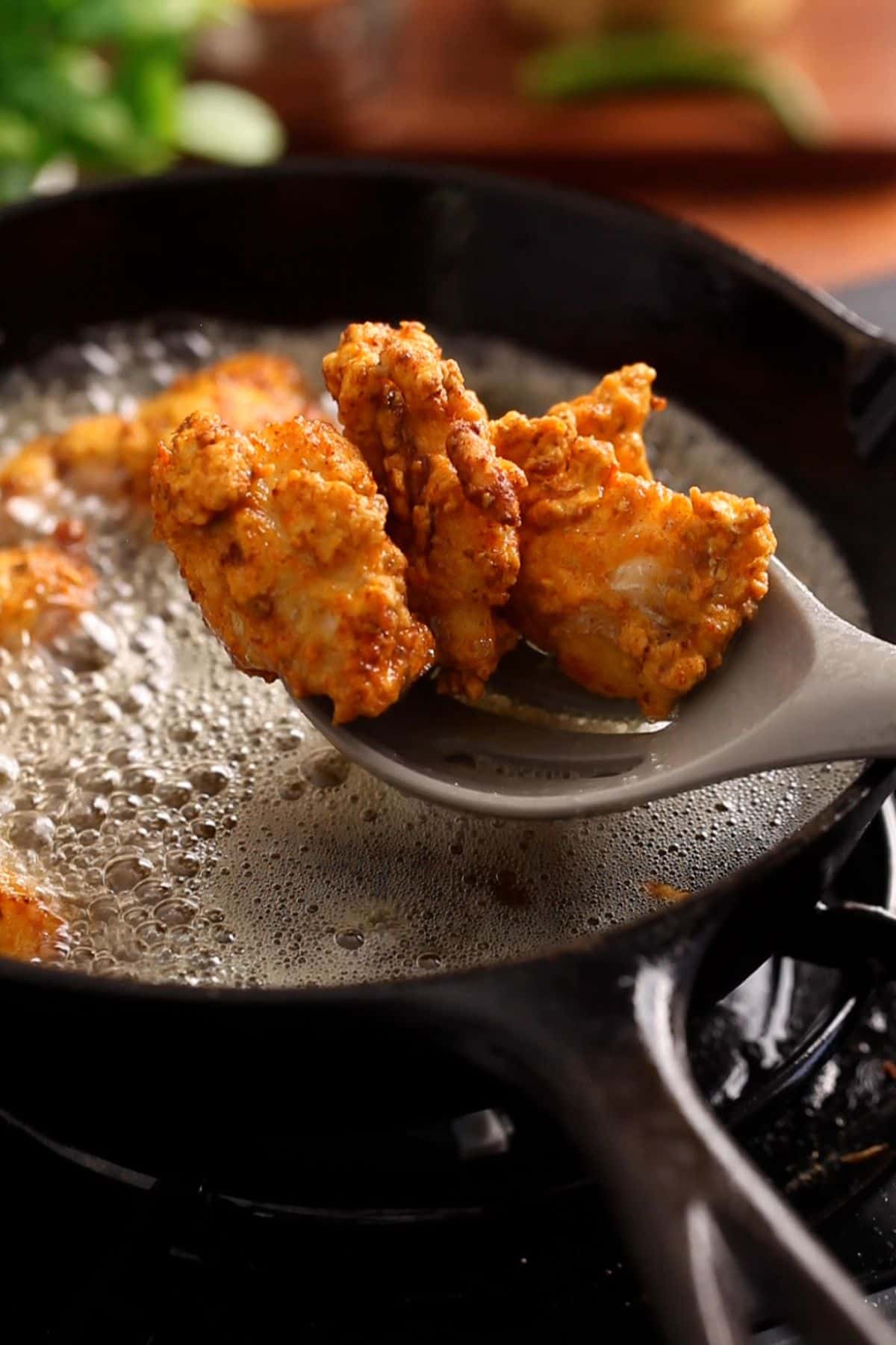 Crispy golden fish pakora are drianed after deep frying.