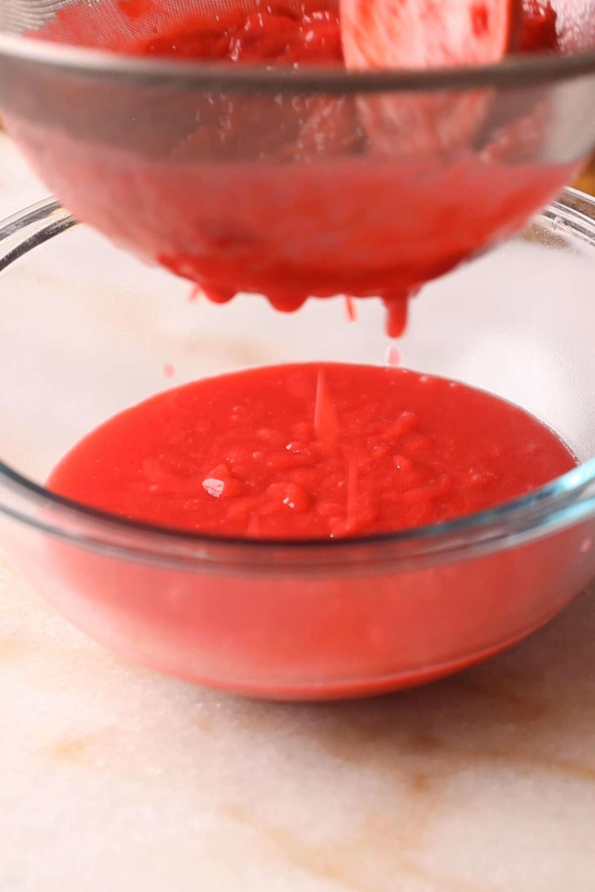 Strain the plum curd filling over a soup mesh. 