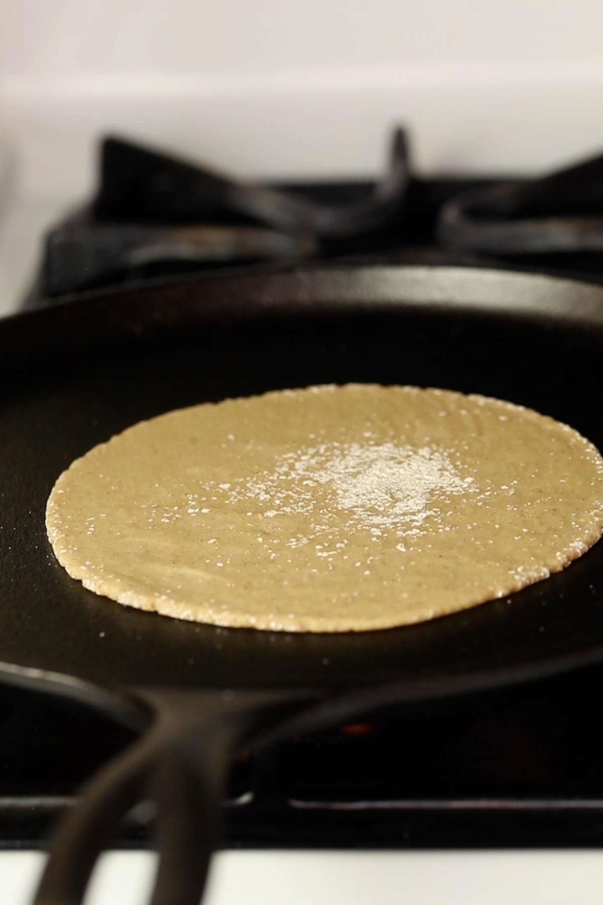 Place the oats roti on a hot cast iron griddle to cook. 