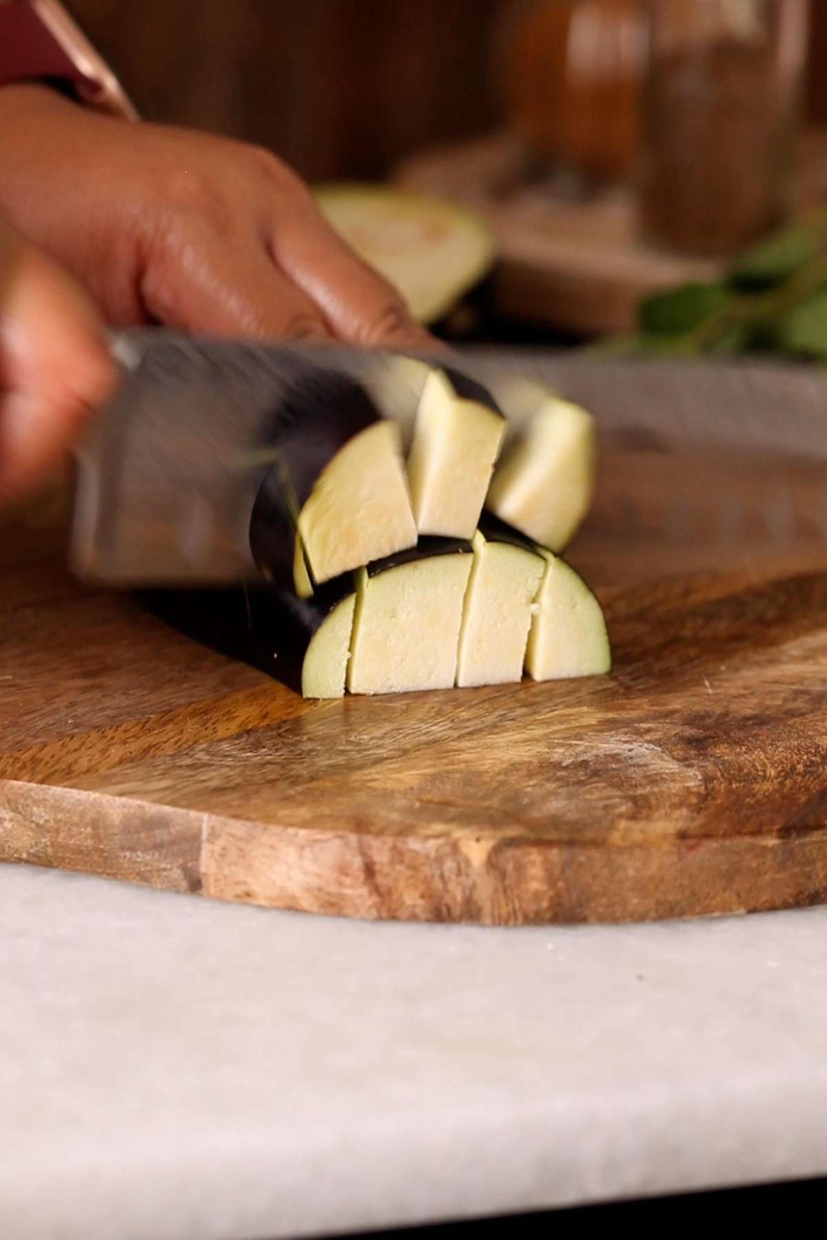 Cutting eggplant in chunks.