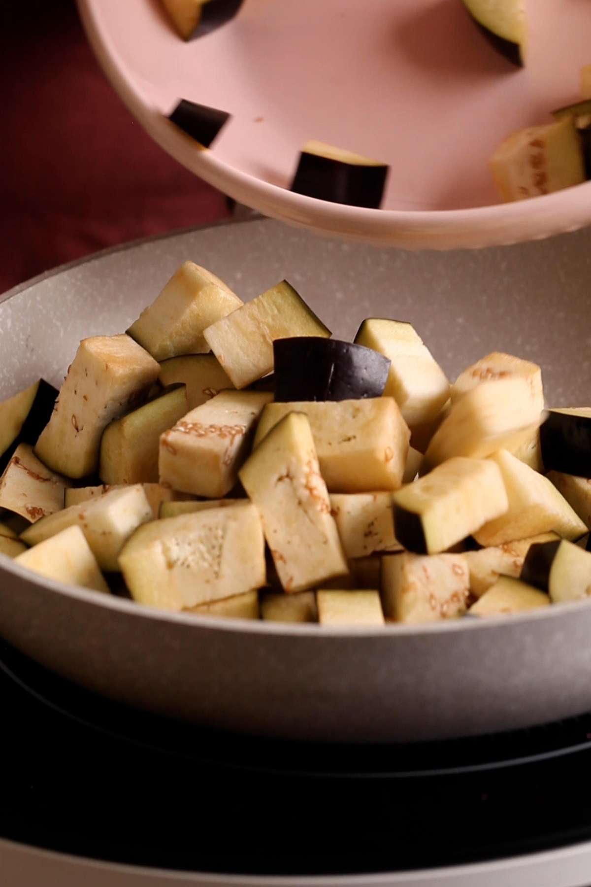 Add eggplant chunks to a pan. 
