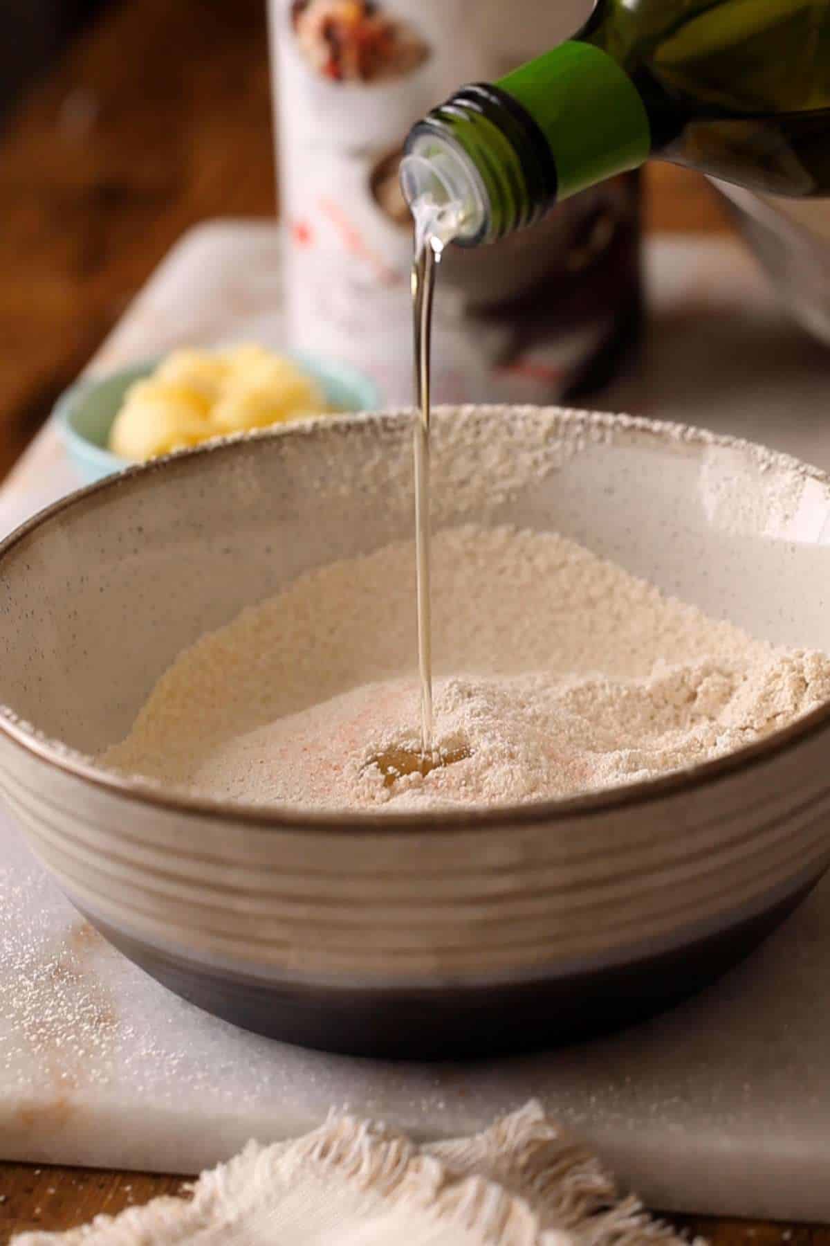 Adding oil to the sieved flour mixture. 