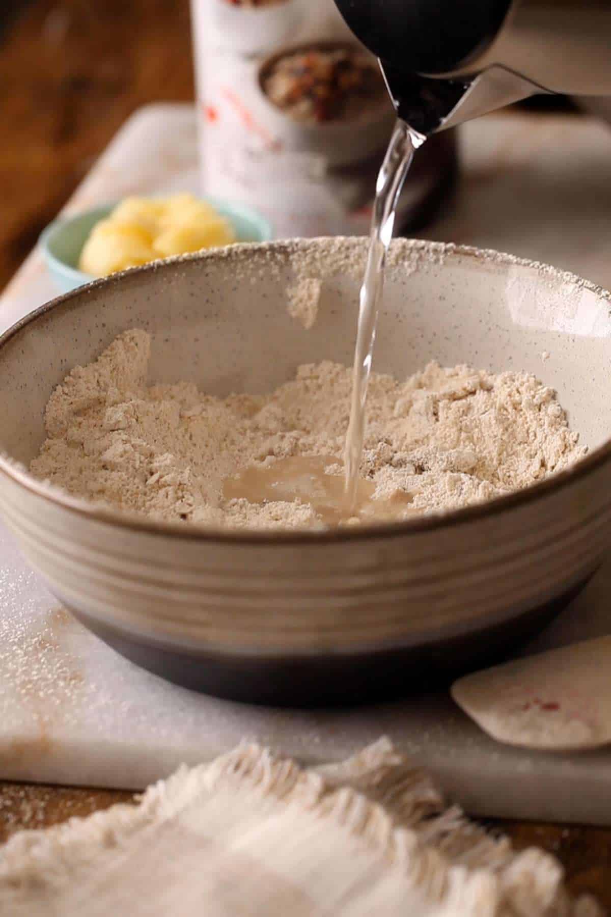Adding boiling water to the sieved flour mixture.