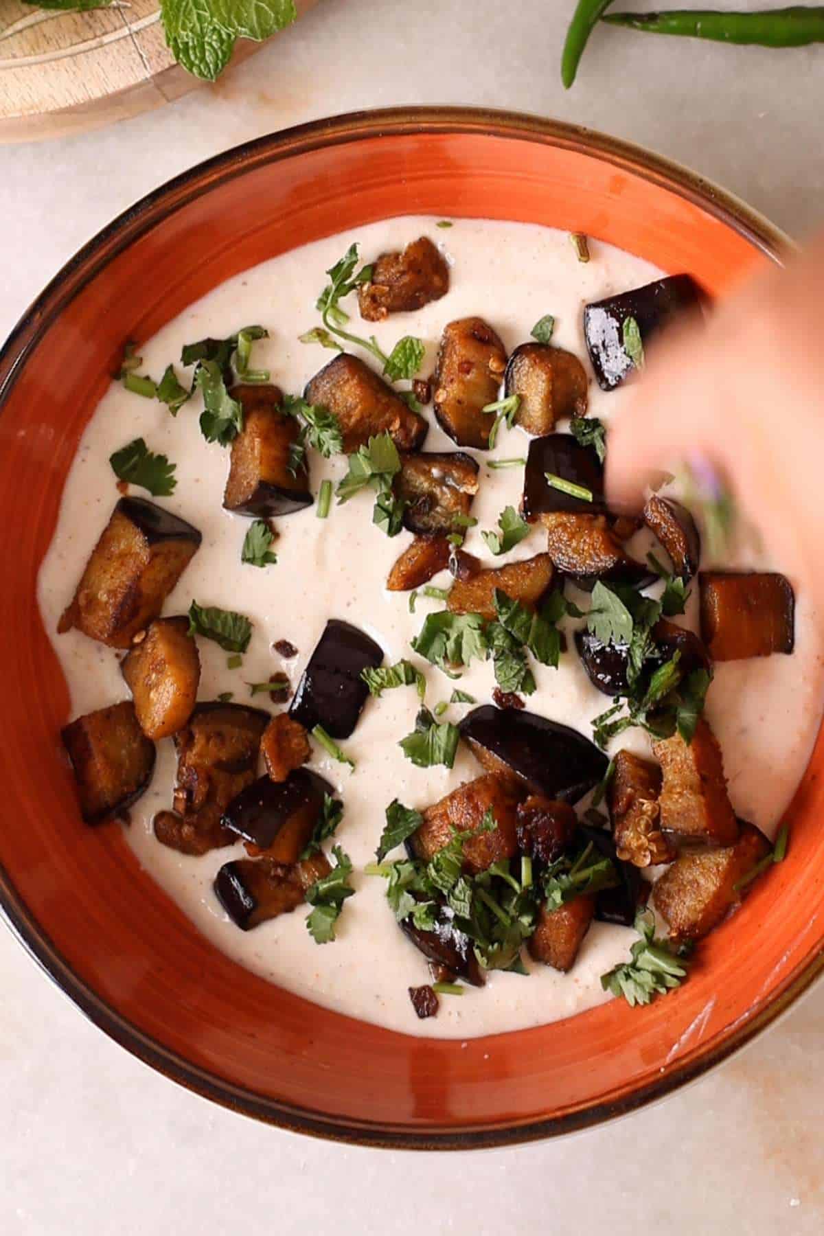 Make alternating layers of spiced yogurt, eggplant and herbs.
