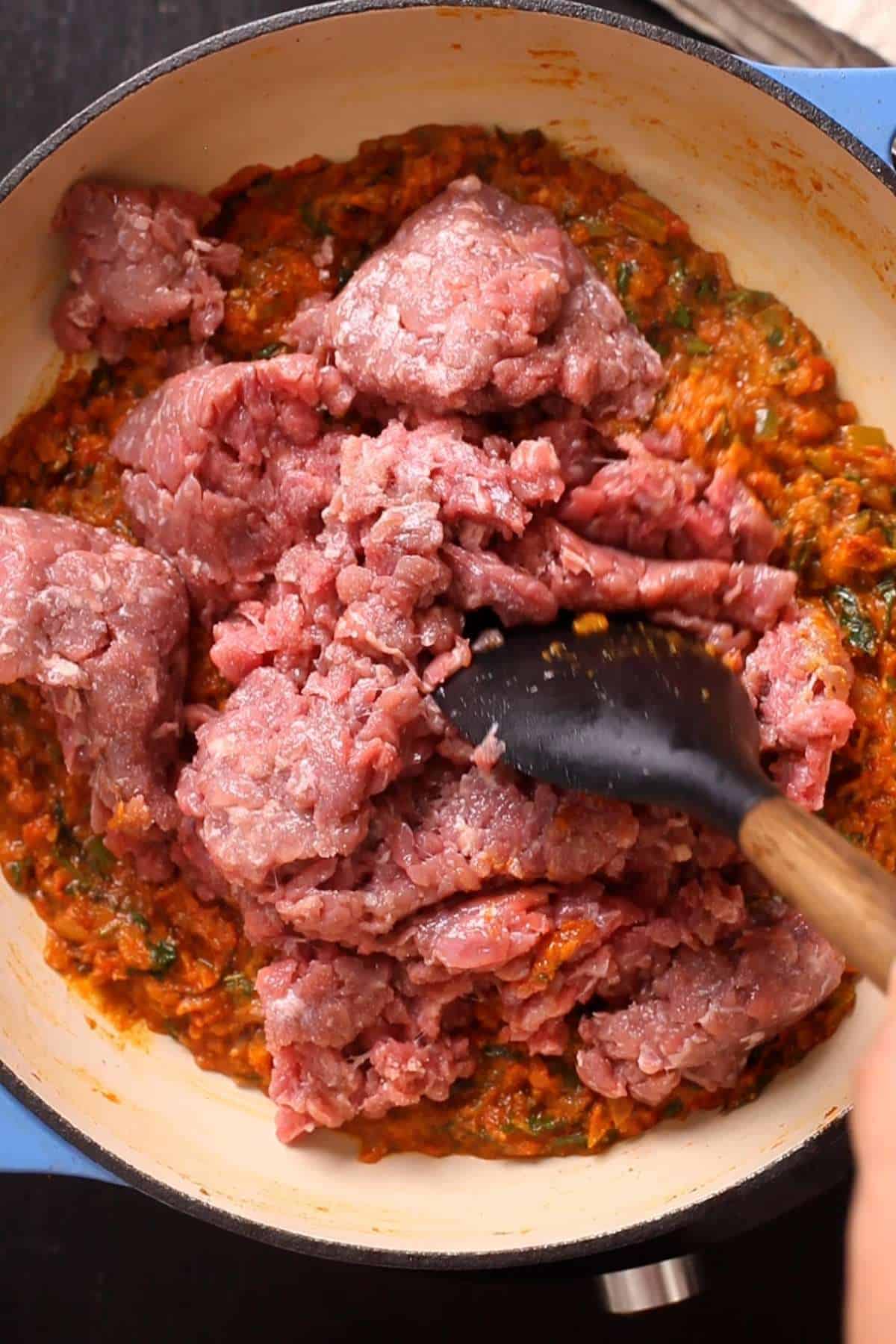 Break down minced goat for browning. 