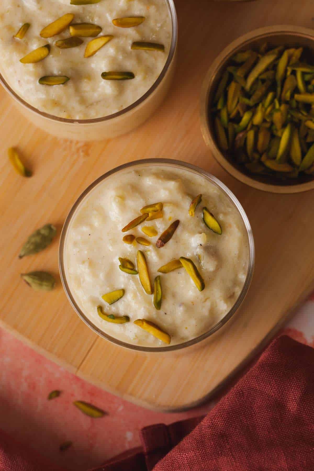 Closeup shot of bottle gourd kheer topped with silvered pistachios.