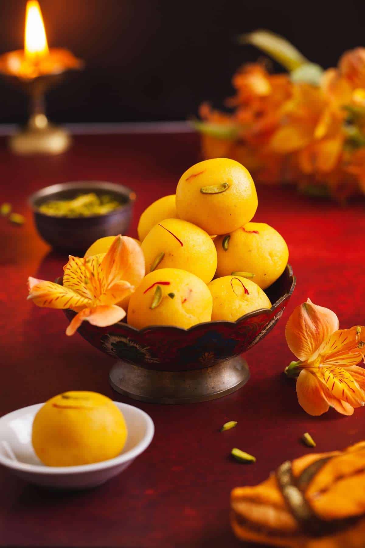 Stack of ladoo in a red gold bowl. 