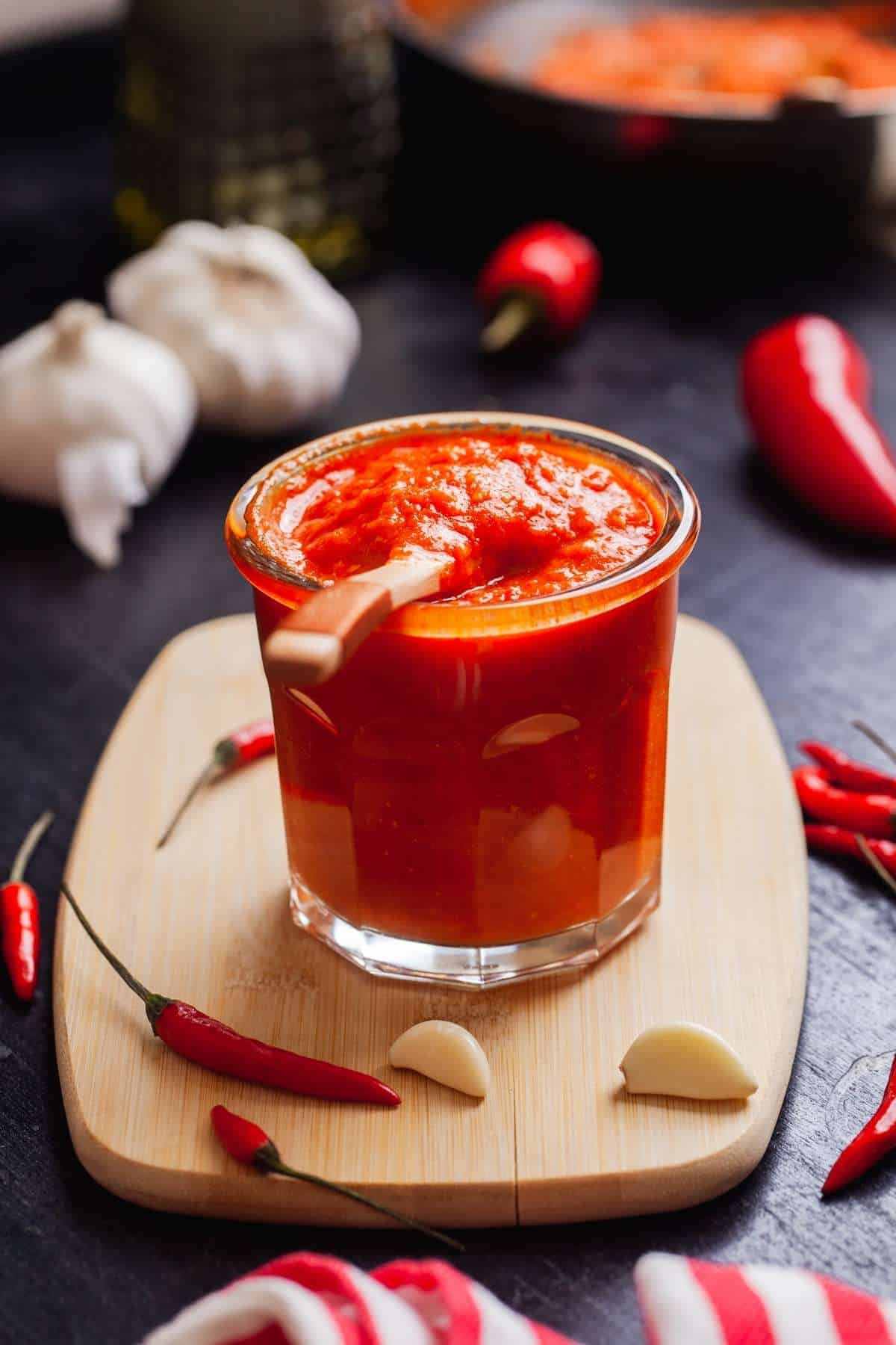 Hot Garlic Sauce in back light with ingredient sacttered around. 