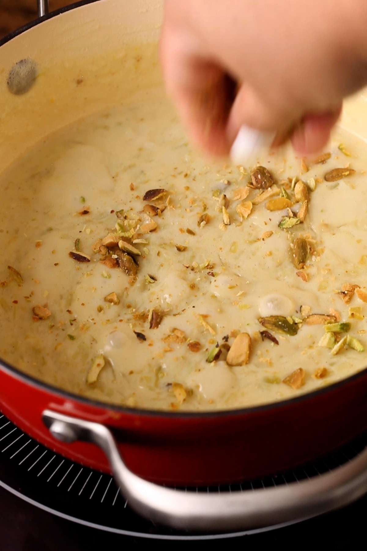 Topping the kheer with chopped pistachios.