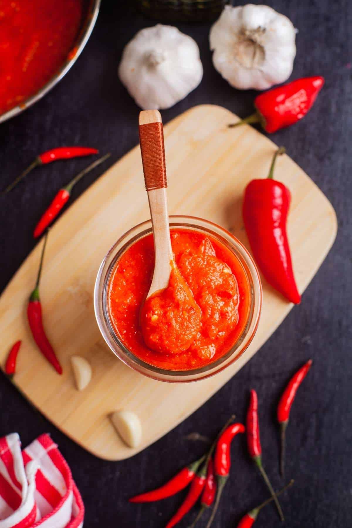 Overhead view of chilli garlic sauce on a wooden board. 