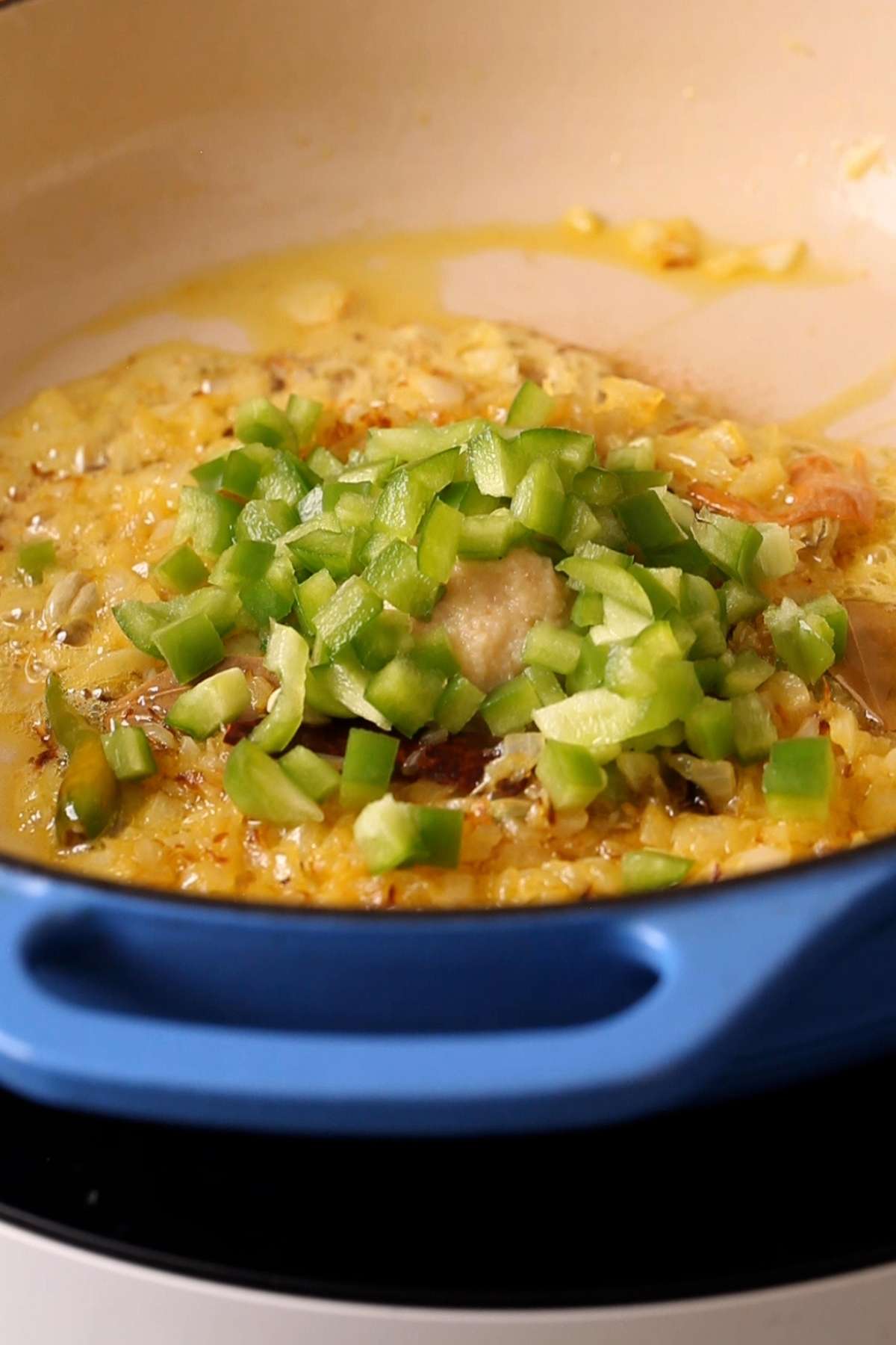Ginger garlic paste and chopped bell pepper added to browned onions. 