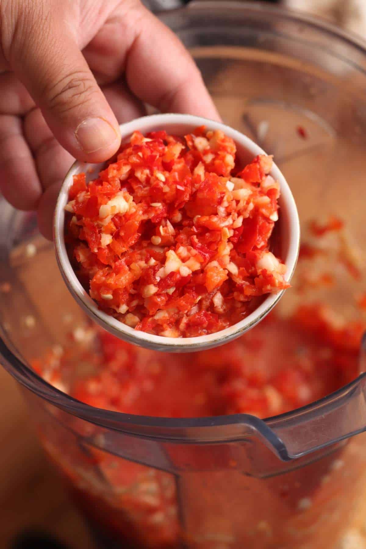Coarsely crushed peppers and garlic in a white bowl.