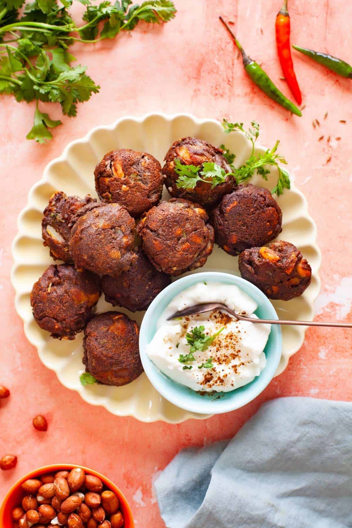 Kuttu Ke Pakode in a fluted ivory colored plate with bowl of yogurt.