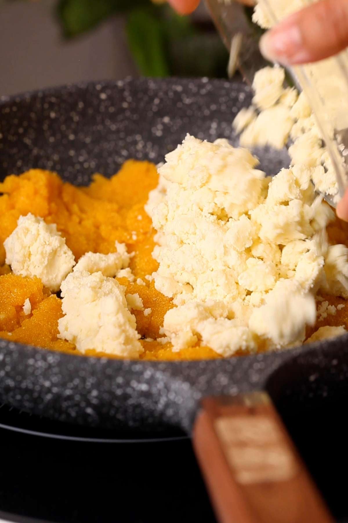 Adding mawa or khoya to pan.