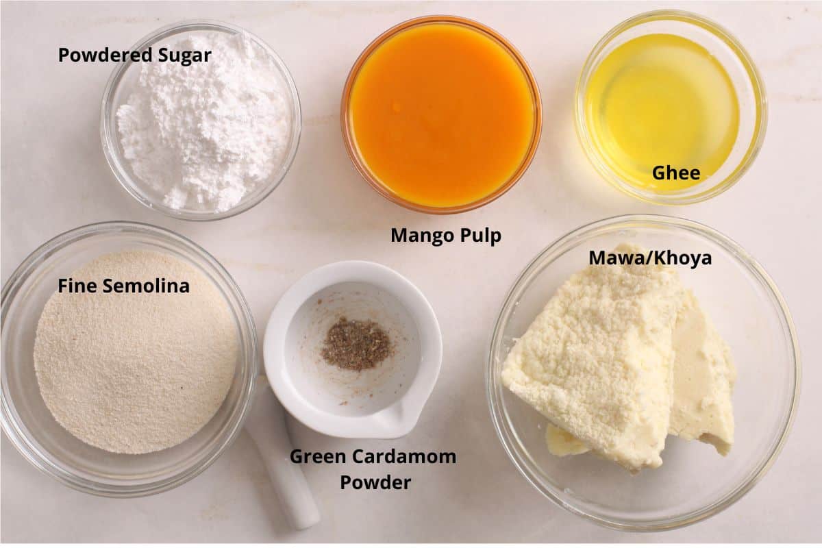 Ingredients needed to make mango ladoo on a marble background. 