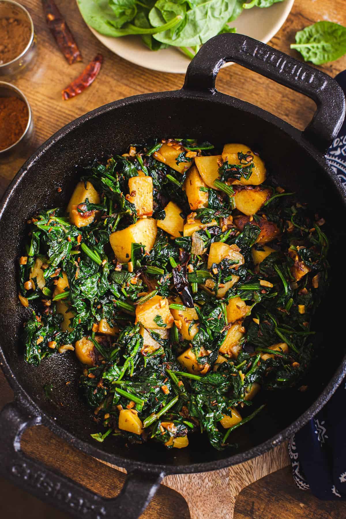 Aloo Palak in a cast iron wok.