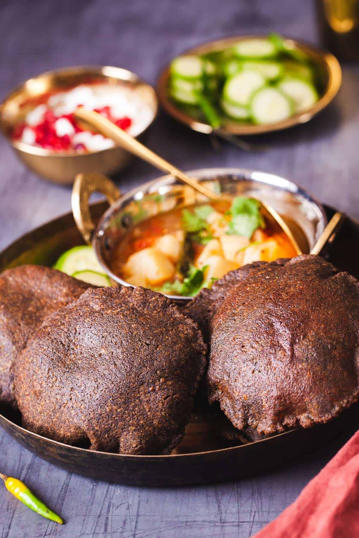 Side view of kuttu ke late ki puri with potato sabzi.