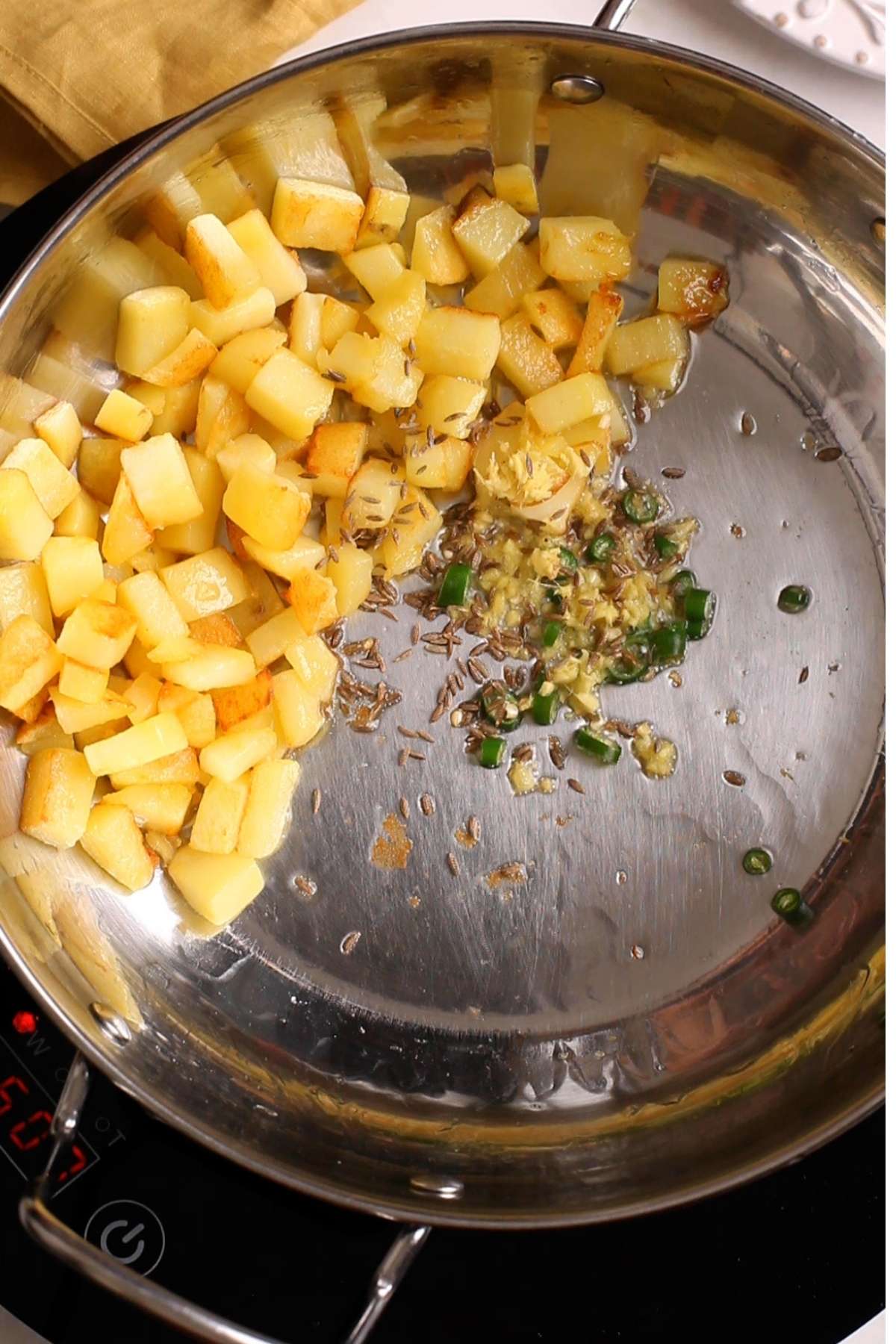 Adding tempering of cumin, ginger & green chillies to make sago khichdi.