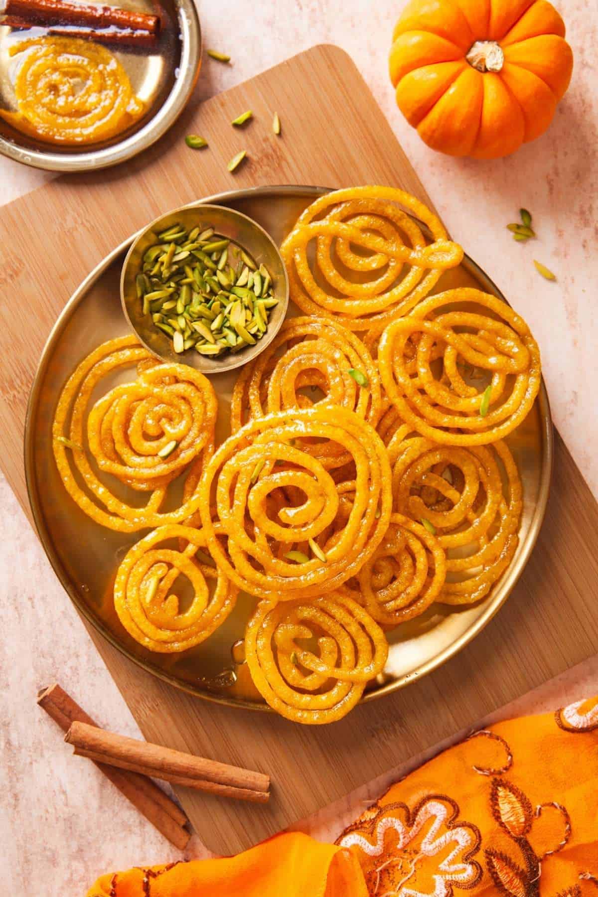 A batch of jalebi made with pumpkin puree and spices on a gold plate. 