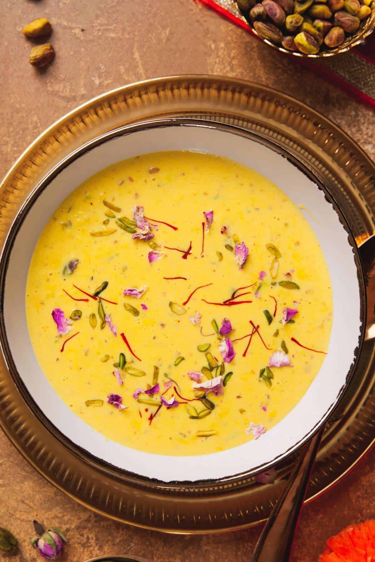 Close up of Instant Rabdi in a white and gold bowl placed over a gold plate.
