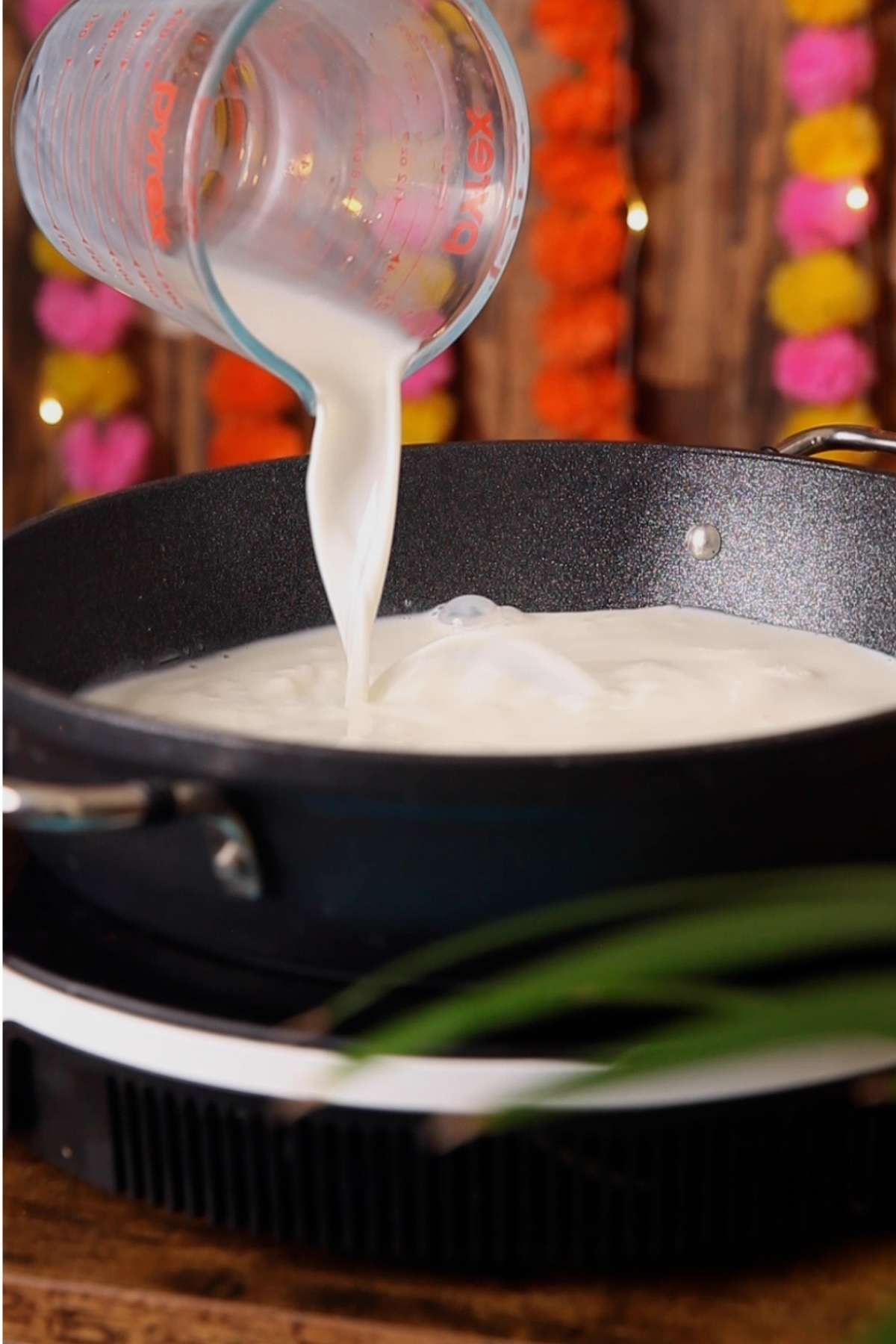 Pouring milk in a wide pot.