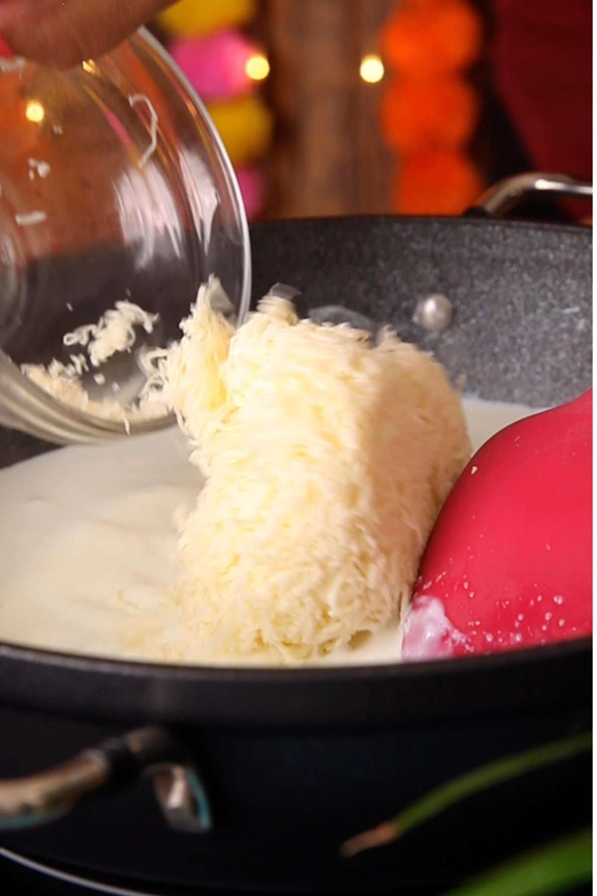 Adding grated paneer to reduce milk.