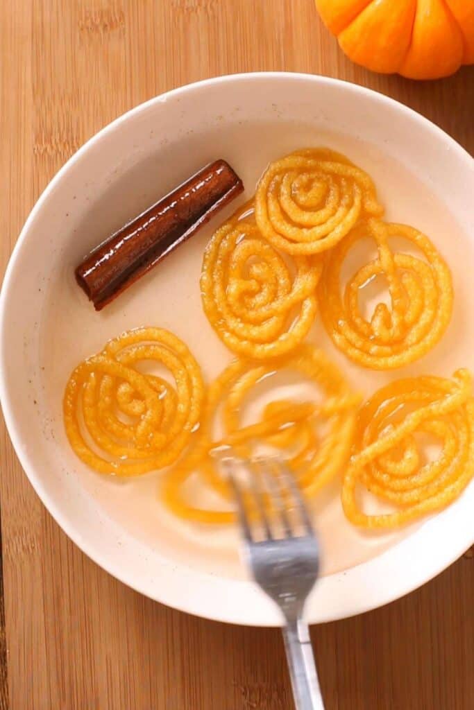 Dunk Jalebis in sugar syrup.