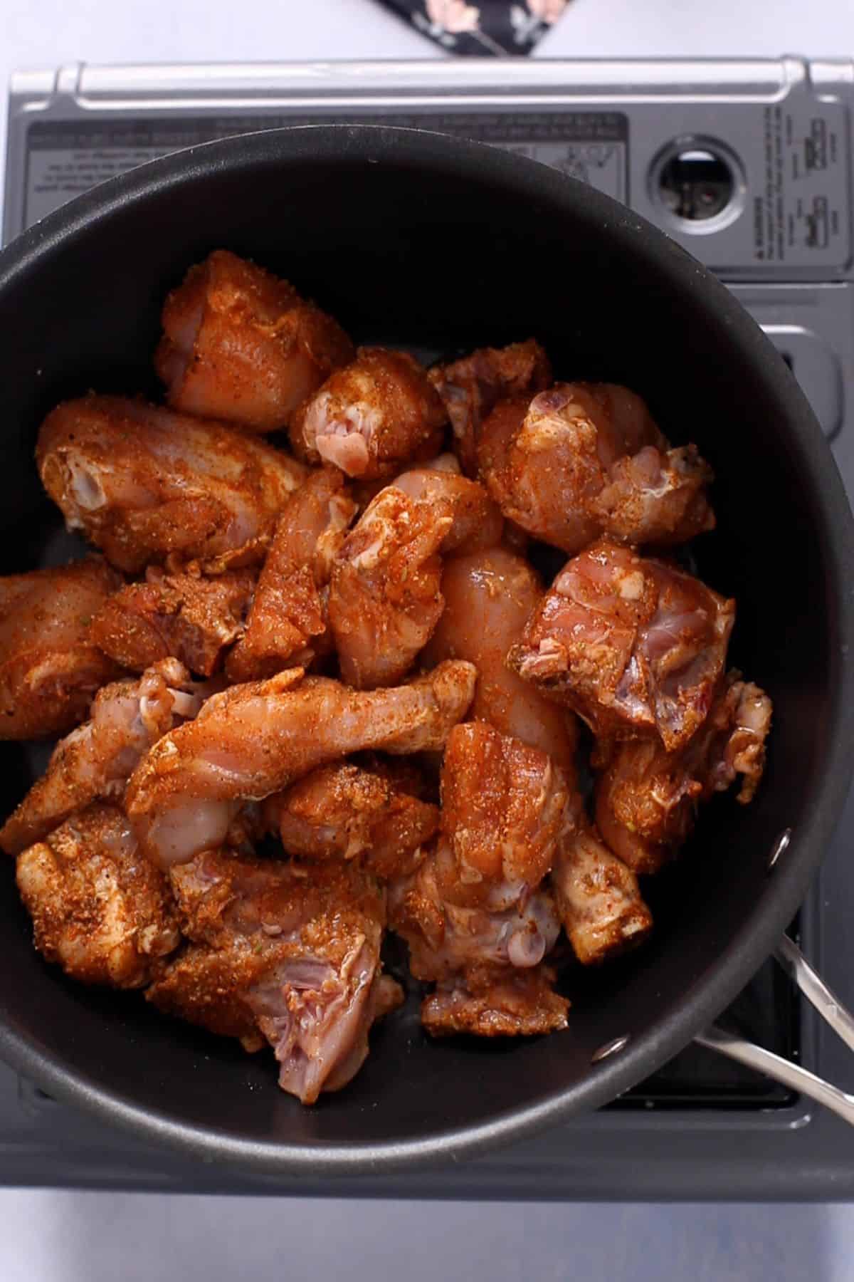 Spice rubbed chicken is added to hot oil.