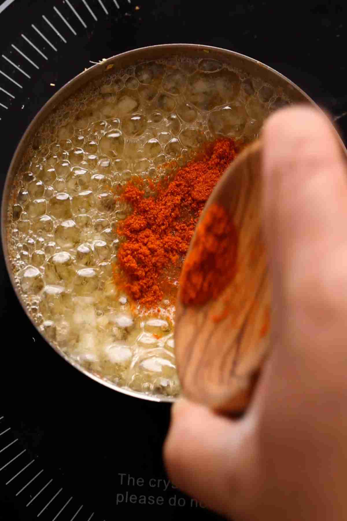 Add red chili powder to tadka.