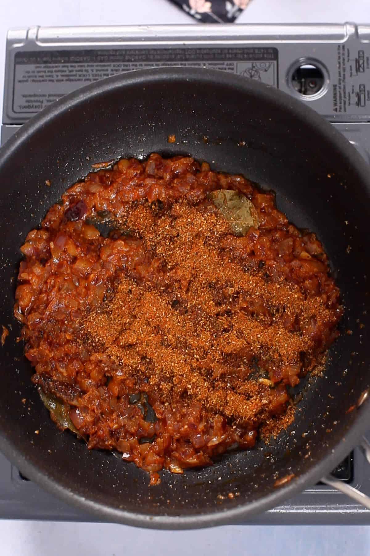 Bhuna masala powder is sprinkle over the cooked tomatoes.