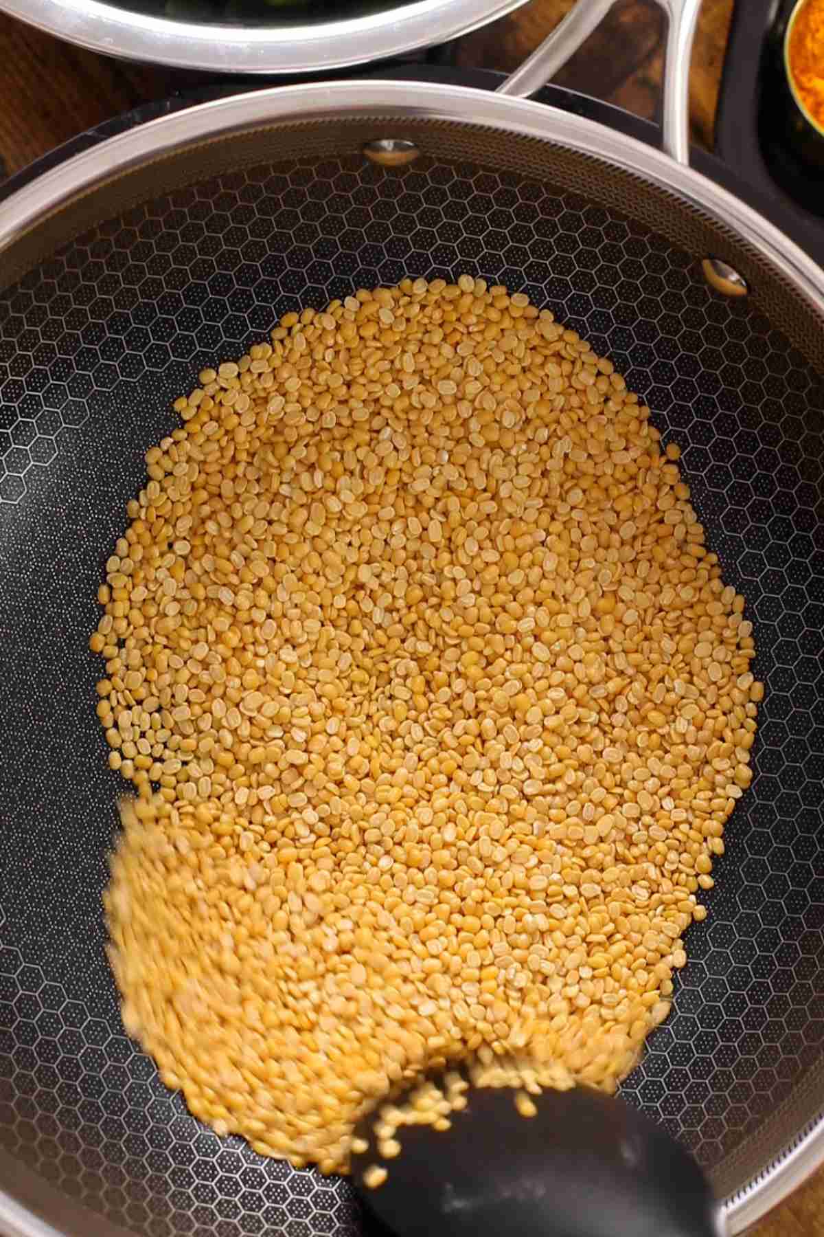 Dry roasting moong lentils in a pan.