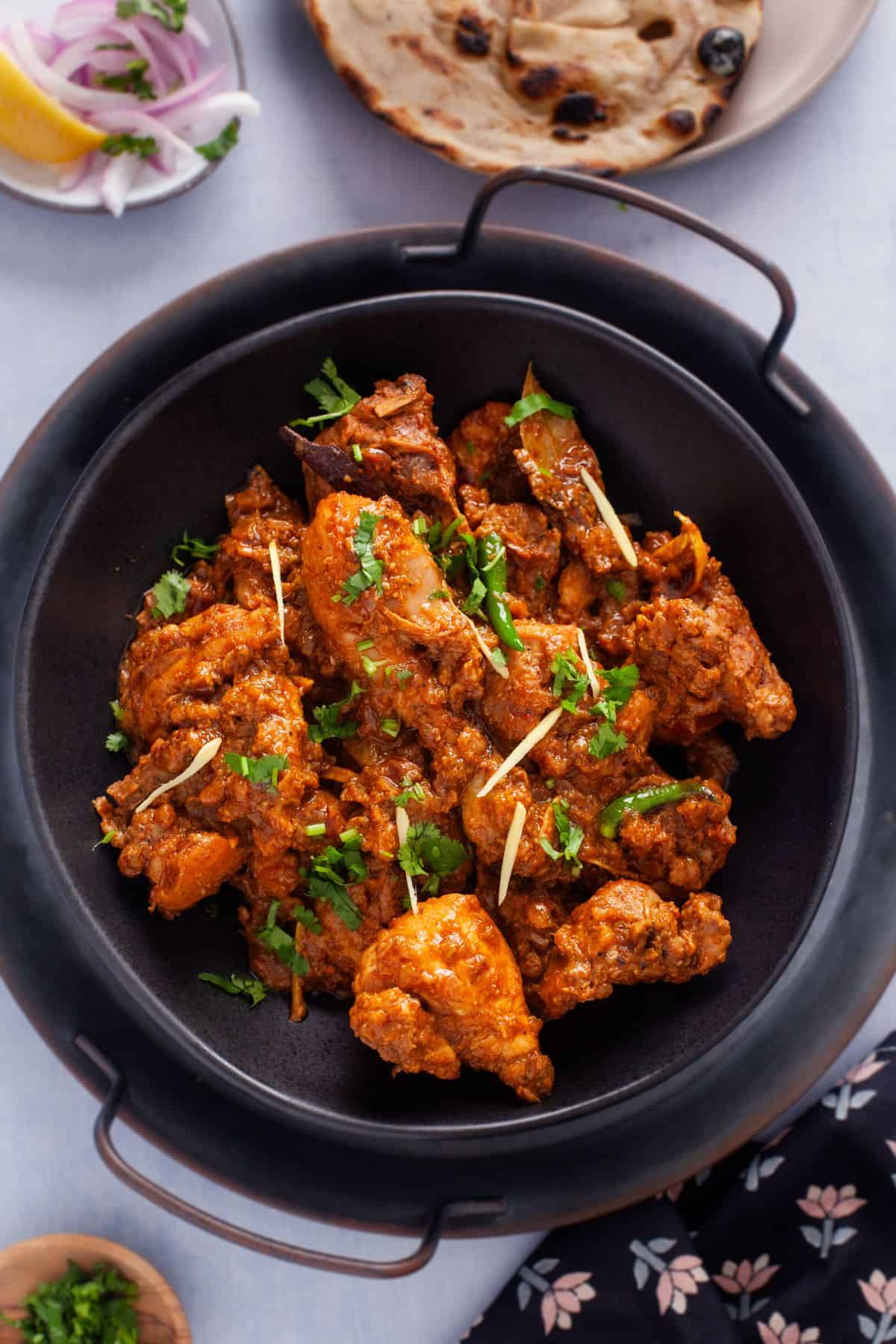 Chicken Bhuna Masala served in a black bowl.
