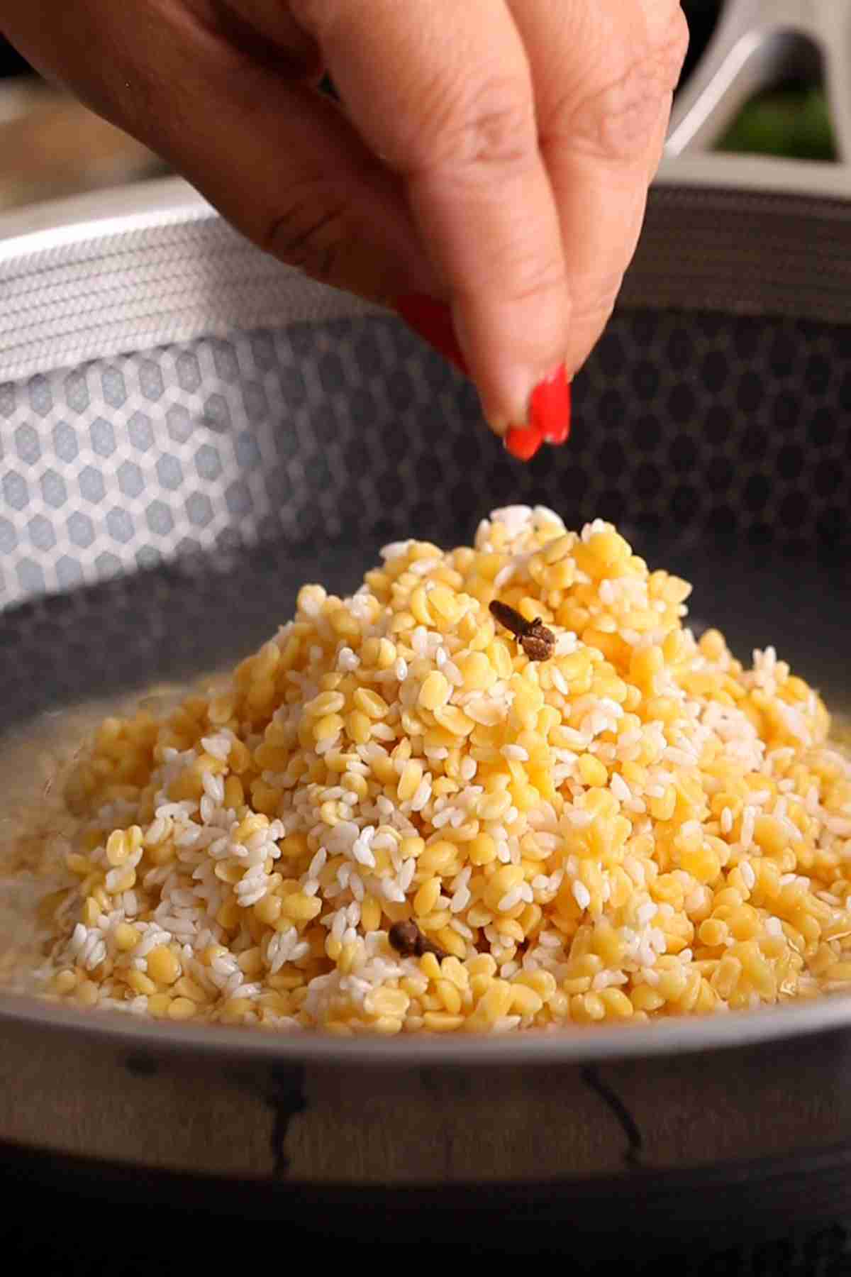 Add lentils to a pot with cloves.