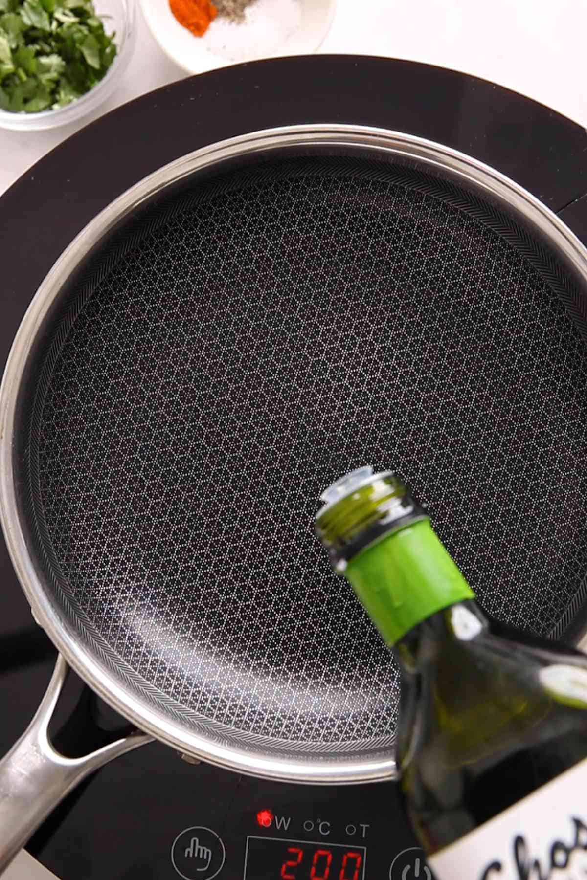 Adding oil to a pan for sautéing potatoes. 