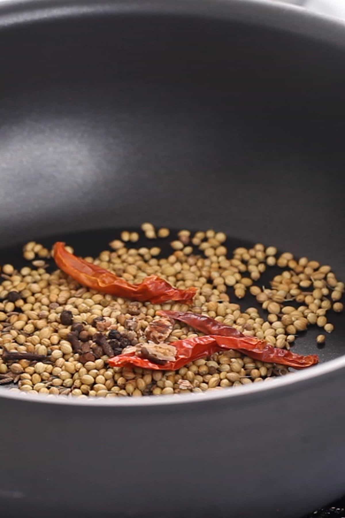 Toasting whole spices to make bhuna masala. 