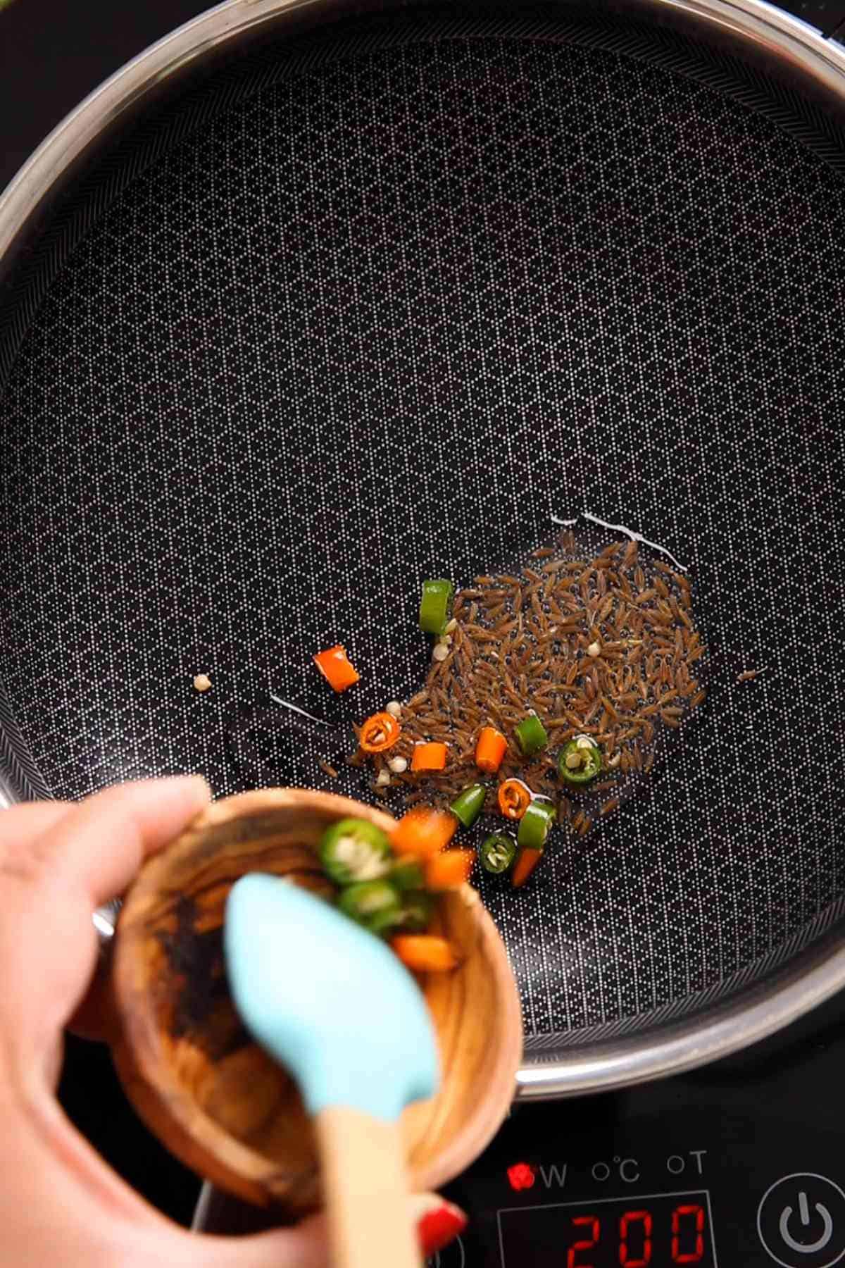 Temper oil with cumin seeds & green chilies.