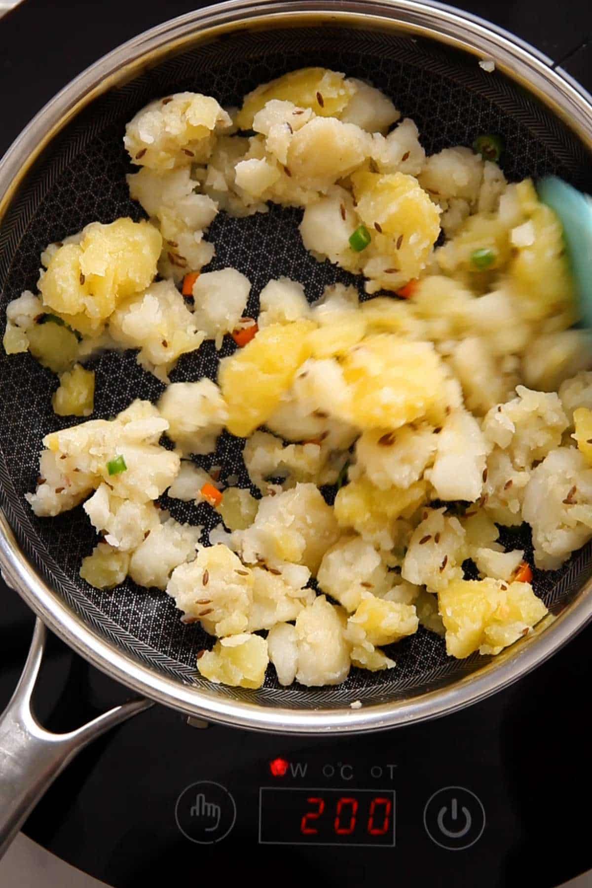 Cooking potatoes with cumin oil.