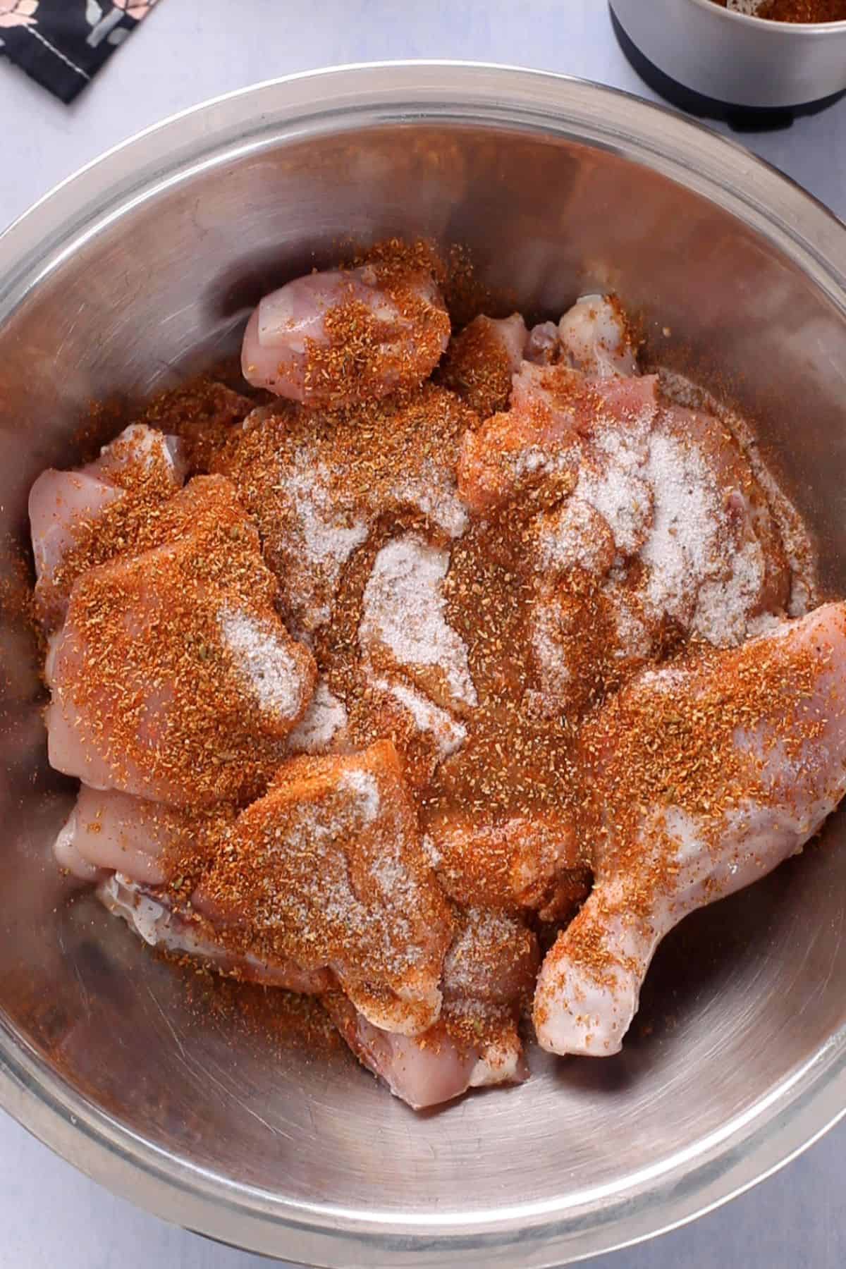 Raw chicken is sprinkled with salt, bhuna masala powder and lemon juice.