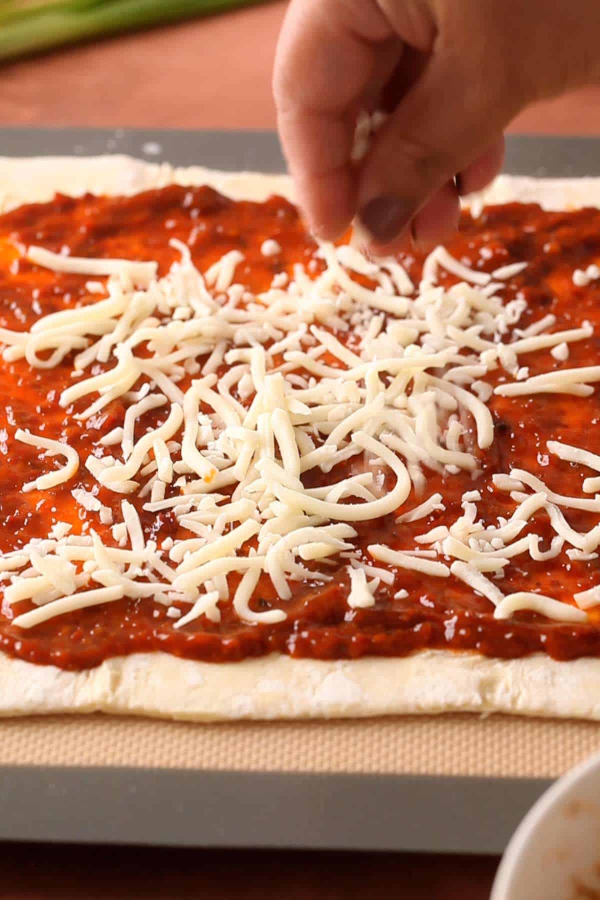 Add shredded cheese on the pastry.