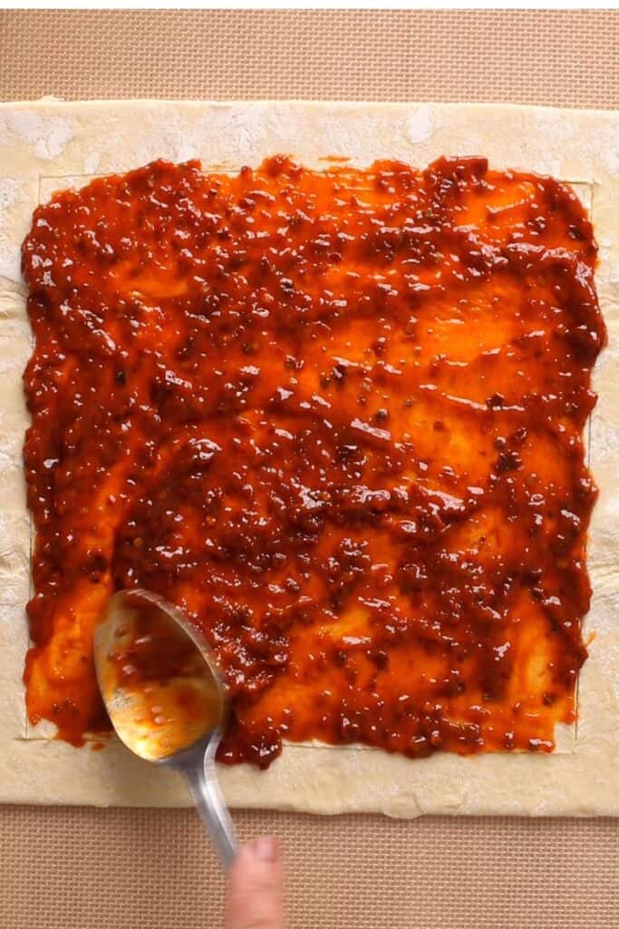 Spread Schezwan Chutney on the pastry.