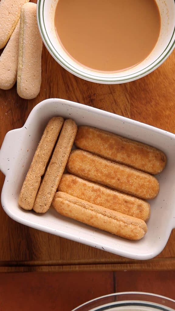 Dip the ladyfinger in cooled chai and layer on the dish.