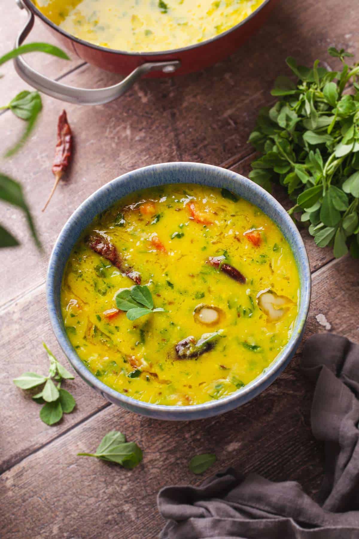 Warm Methi dal in a blue bowl cover a rustic back ground.