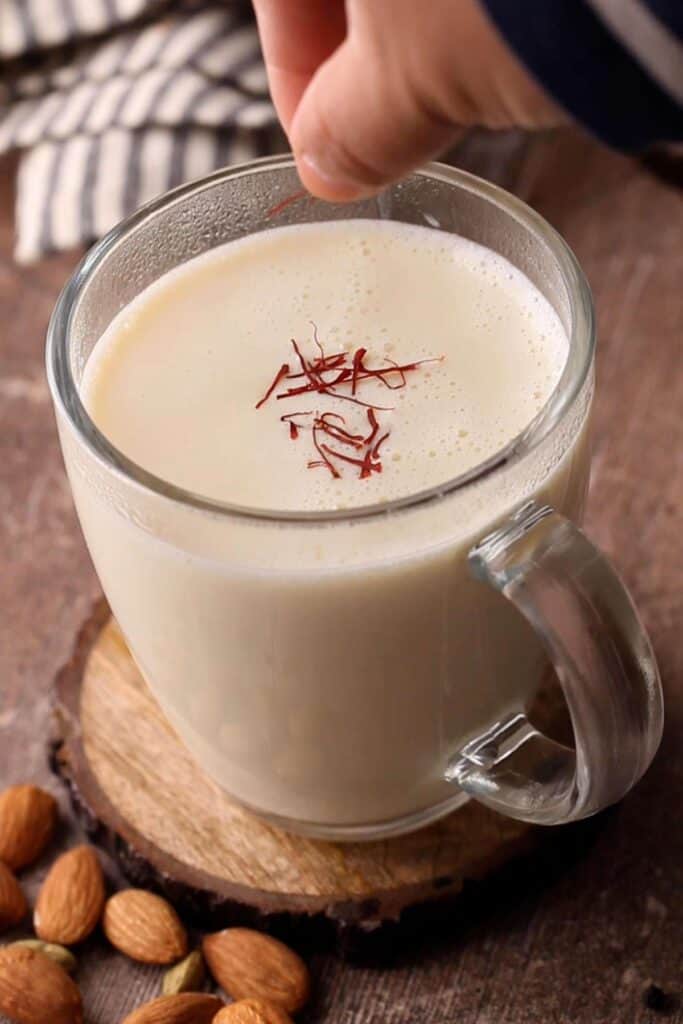 Adding saffron to badam milk.