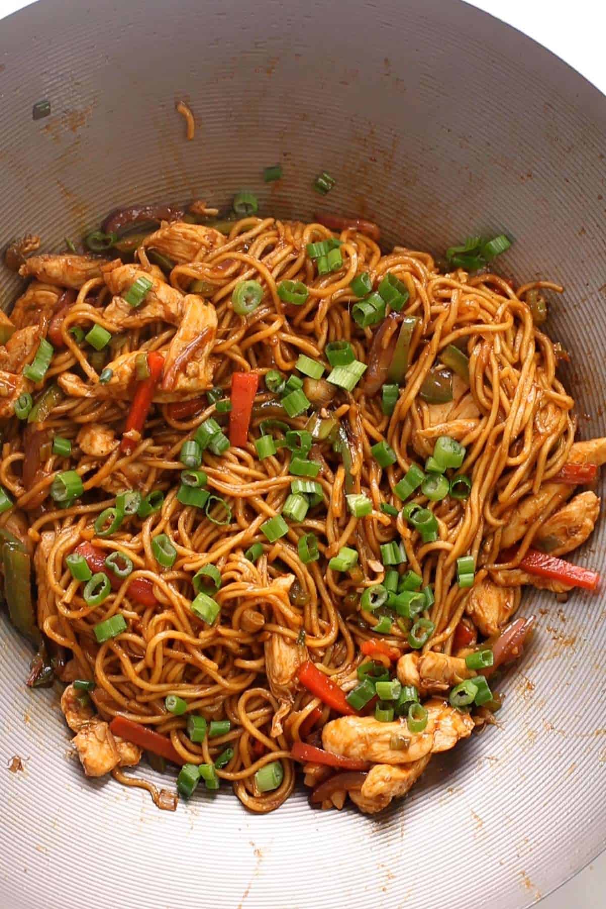 Sprinkle green onions on chicken hakka noodles. 