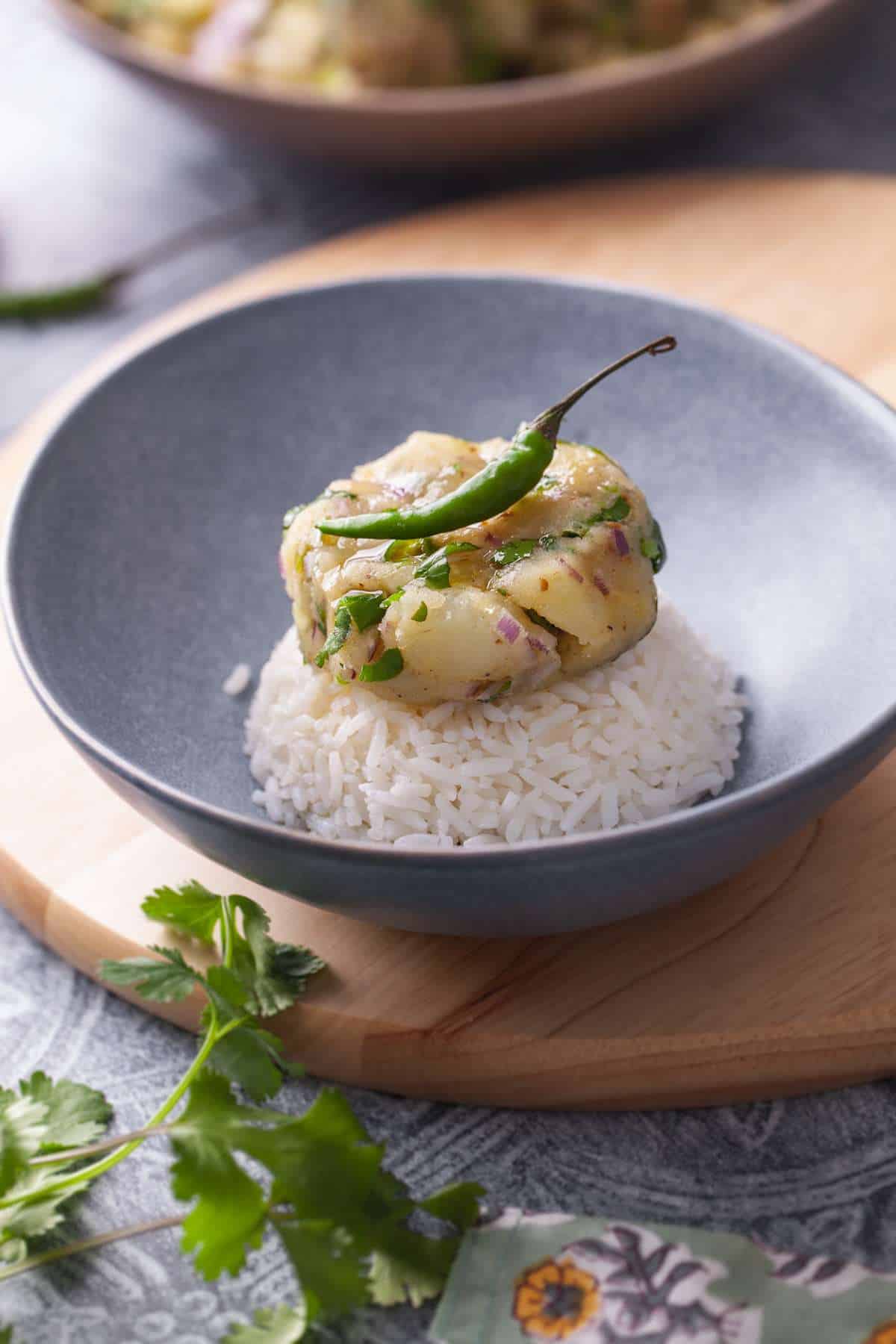 Aloo Ka Bharta served over steamed rice with a drizzle of ghee and green chilli.