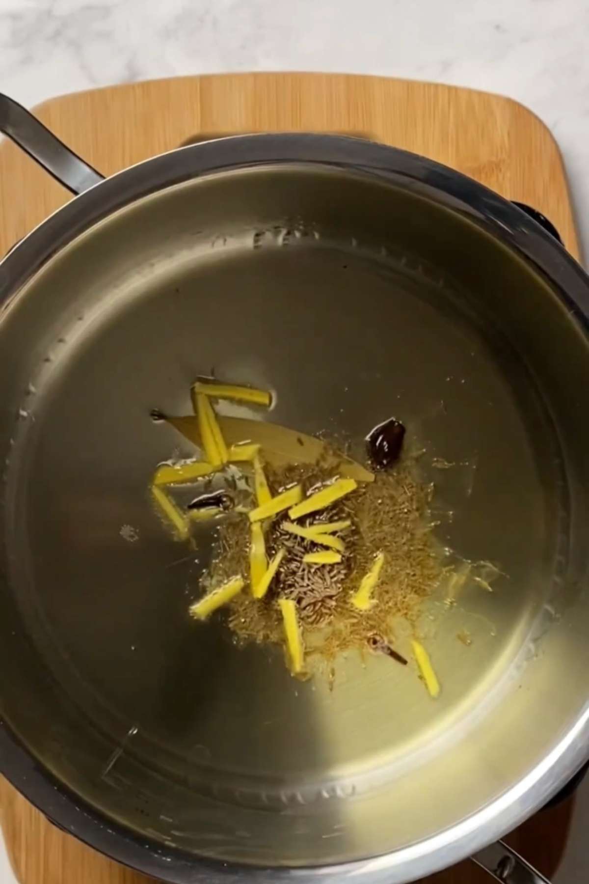 Temper the ghee with spices and ginger.